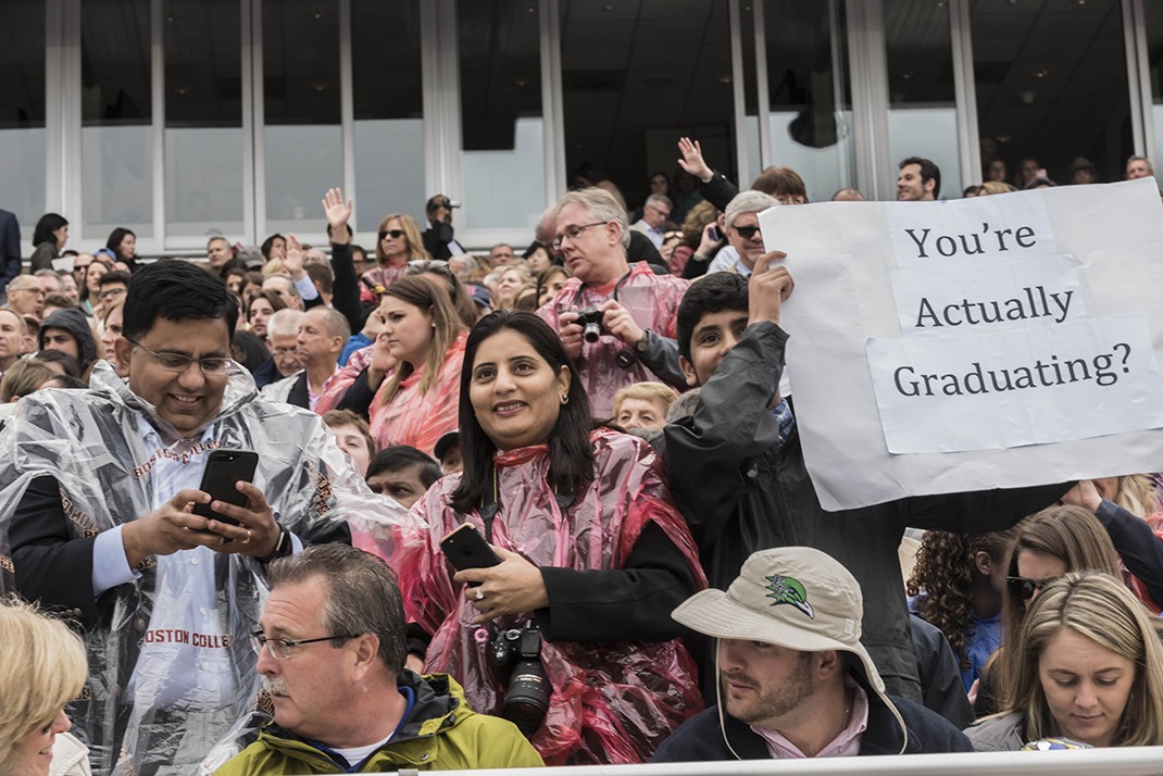 Family members holding up messages to their graduate Family members holding up messages to their graduate