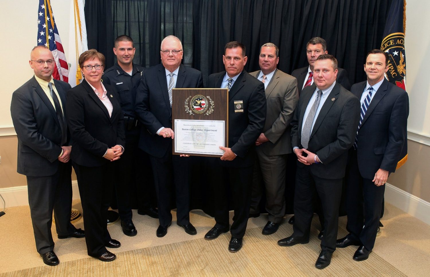 Boston College Executive Director of Public Safety and Police Chief John King, fourth from left, at a ceremony marking BC Police Department's reaccreditaiton. From left, Massachusetts Police Accreditation Commission Vice President Russ Stevens; BCPD Lieutenant and Accreditation Manager Laurene Spiess; BCPD Officer and Accreditation Assessor Robert Wayne; MPAC President Matt Clancy; BC Associate Director of Public Safety and Deputy Chief Tom Atkinson; BC Detective Lieutenant David Flaherty; BCPD Operations Lieutenant Jeff Postell, and BC Financial Vice President and Treasurer John Burke.
