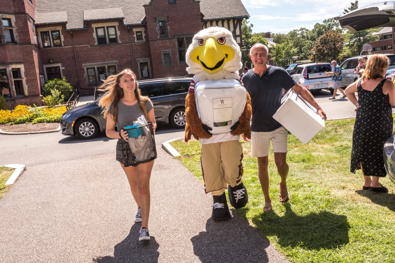 Baldwin, here with Elyse Messick '21 and her dad, Chip, pitches in on Upper Campus. 