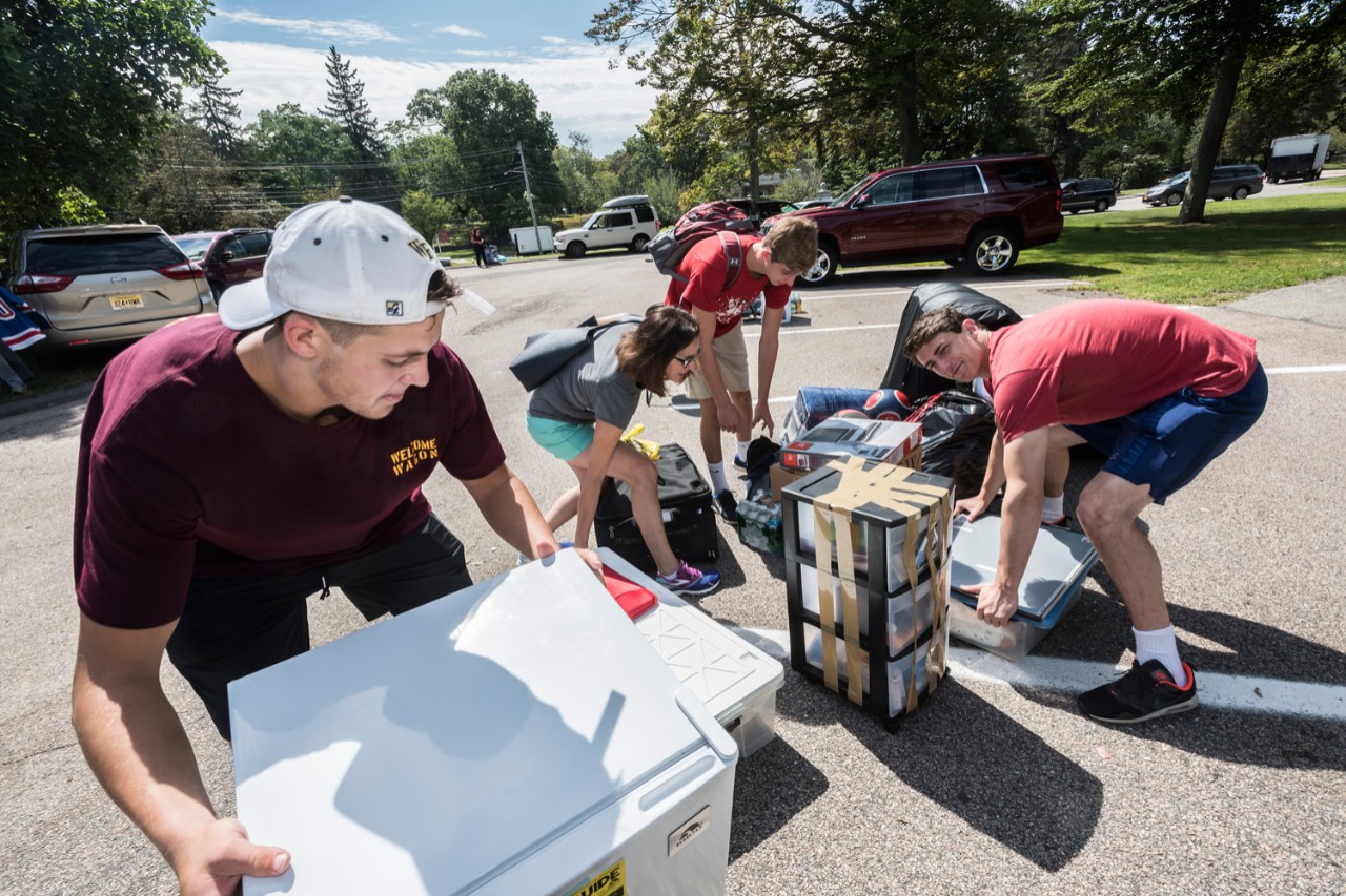 New Carroll School of Management student Daniel Wieber '21 (blonde at rear) Bedminster, N.J., gets help from his mother, Carol, and brother David, CSOM '18. 