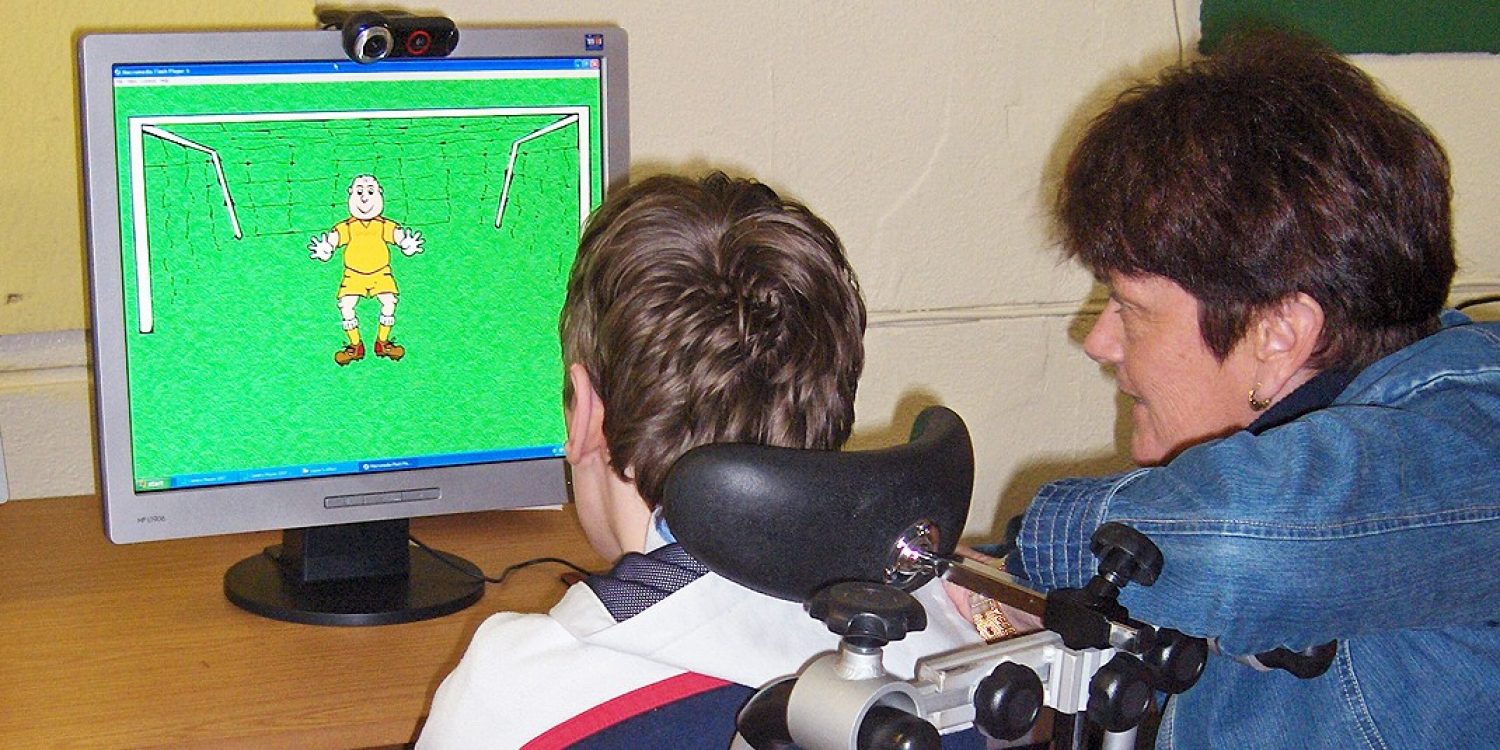 Patrick, a student at the School of the Divine Child in Cork, Ireland learns to use Camera Mouse with teacher Maureen Gates
