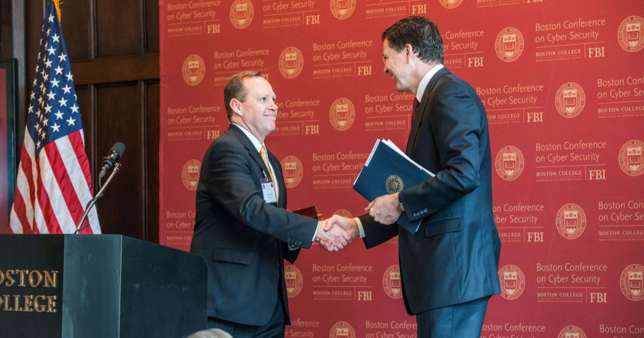 Conference organizer Kevin Powers, founding director of the Woods College Cybersecurity Policy & Governance program, with FBI Director Comey.