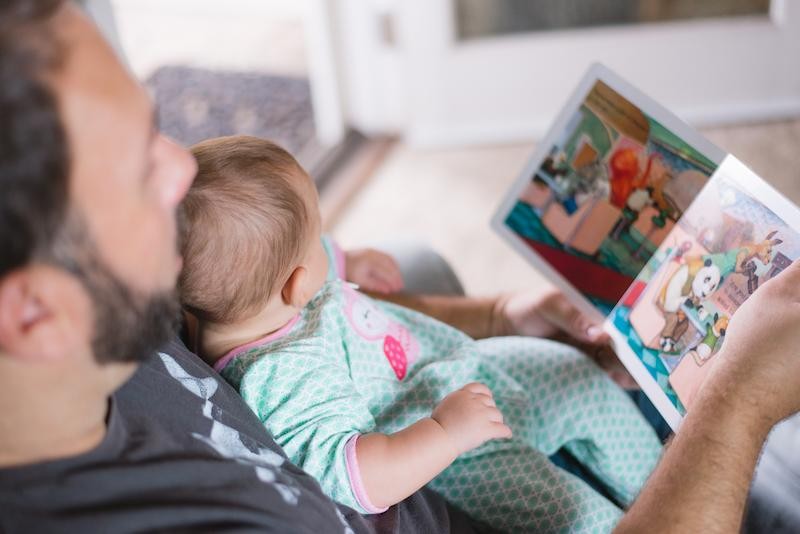 A dad reading to a baby