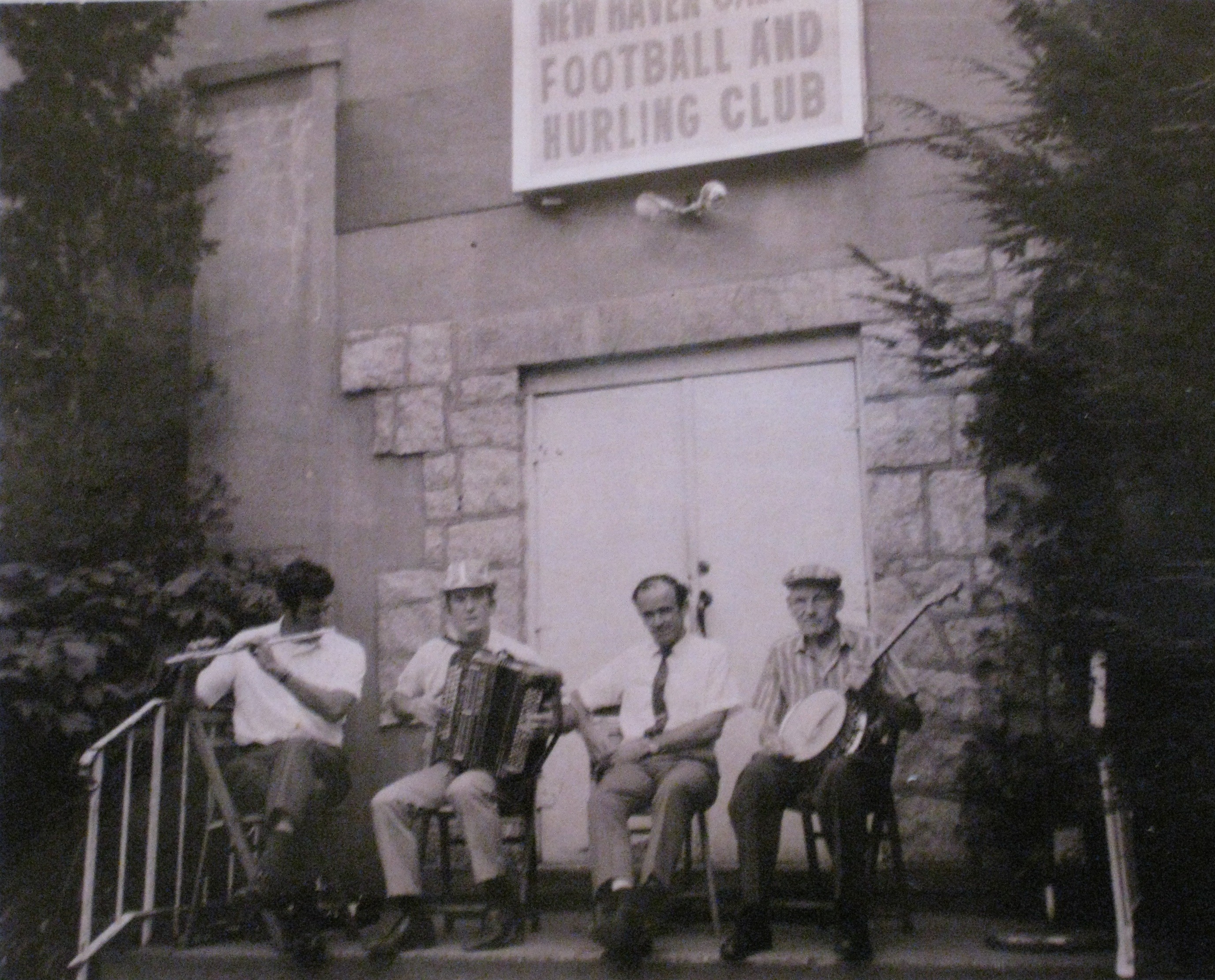Illustrating the link between the GAA and Irish music and culture, a group of traditional musicians playing a session on the front steps of New Haven Gaelic Football and Hurling Club.