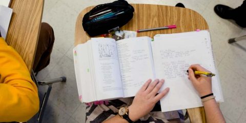 overhead view of a student taking notes in class