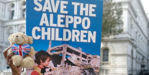 A sign reads 'Save the Aleppo Children'