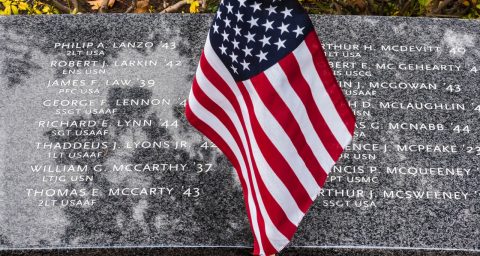 American flag draped over granite memorial