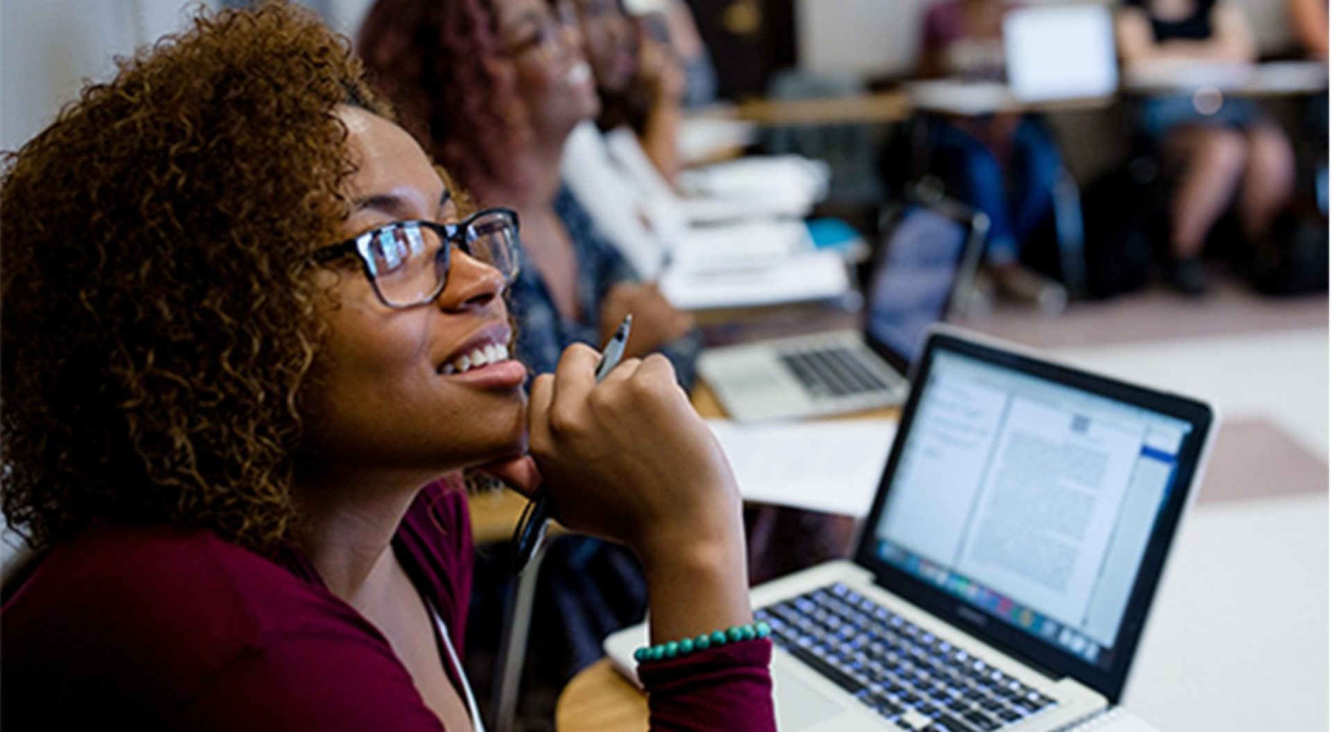 graduate students talk with a professor  in a classroom