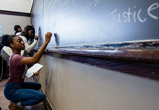 student writing on a chalkboard