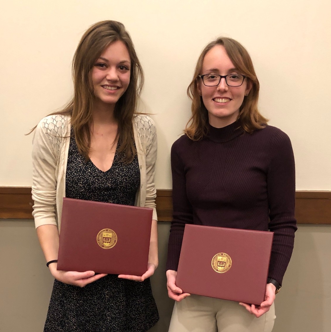 Two woman holding awards