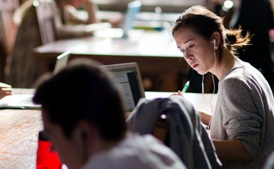 student studying with headphones at laptop