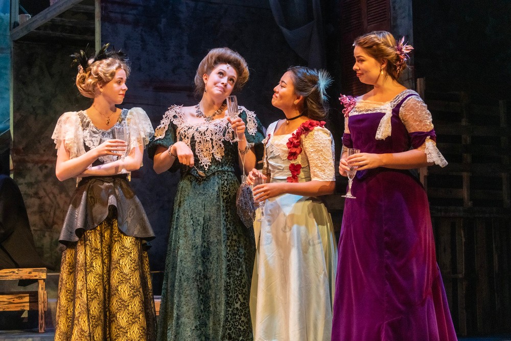 four women in Victorian gowns