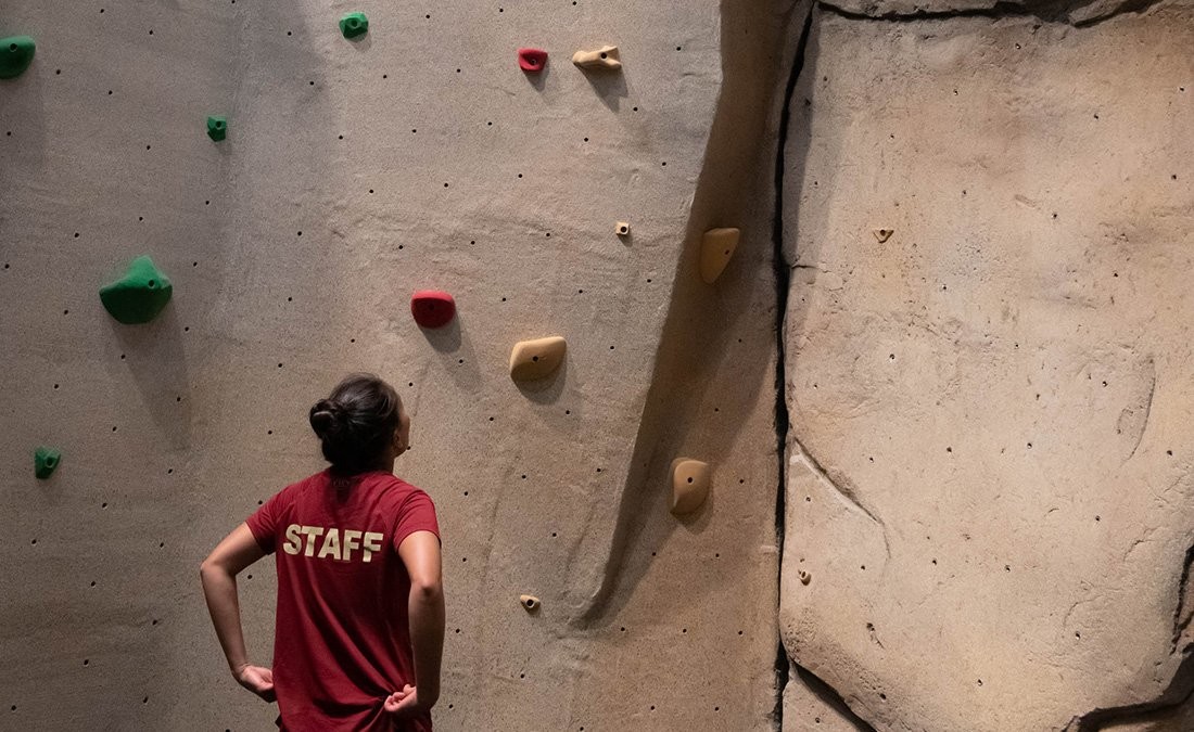 A student climbing a rock wall