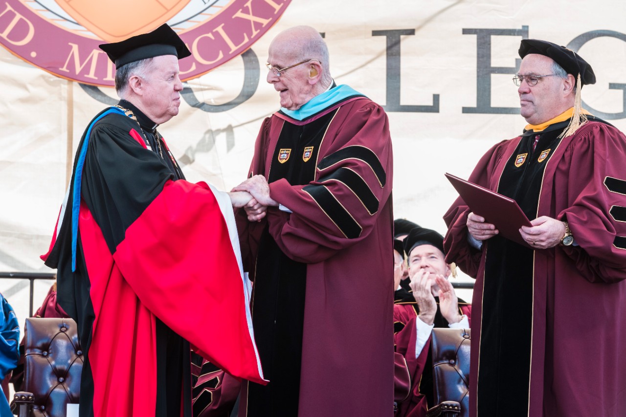 University President William P. Leahy, S.J., congratulates honorary degree recipient and longtime BC administrator Joseph P. Duffy, S.J.,'50, MA'51, STL'58; as BC Board of Trustees Chair Peter K. Markell '77 looks on
