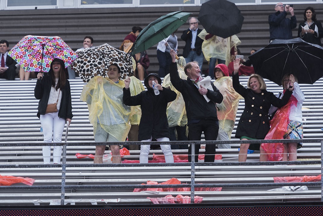Family members dancing with umbrellas in the stands