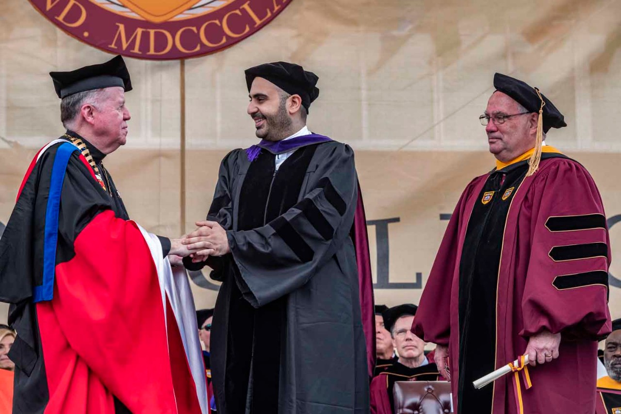 Graduate accepts diploma on behalf of class