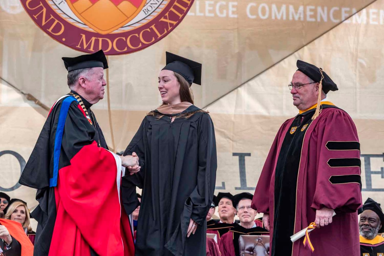 Graduate accepts diploma on behalf of class