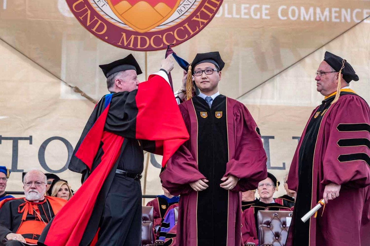 Graduate accepts diploma on behalf of class