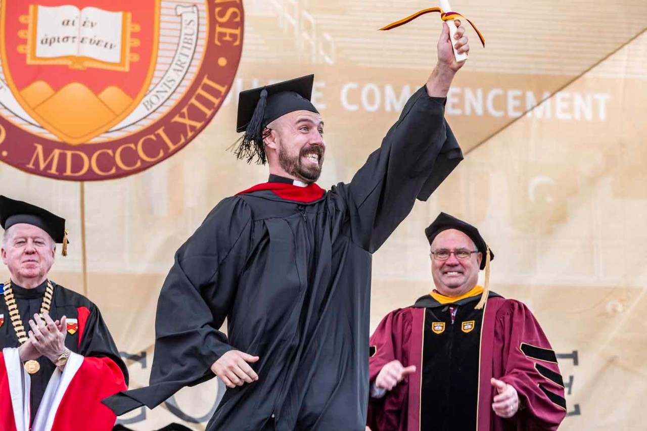 Graduate accepts diploma on behalf of class