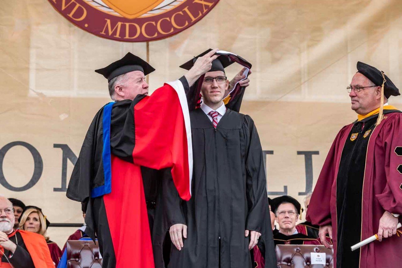 Graduate accepts diploma on behalf of class