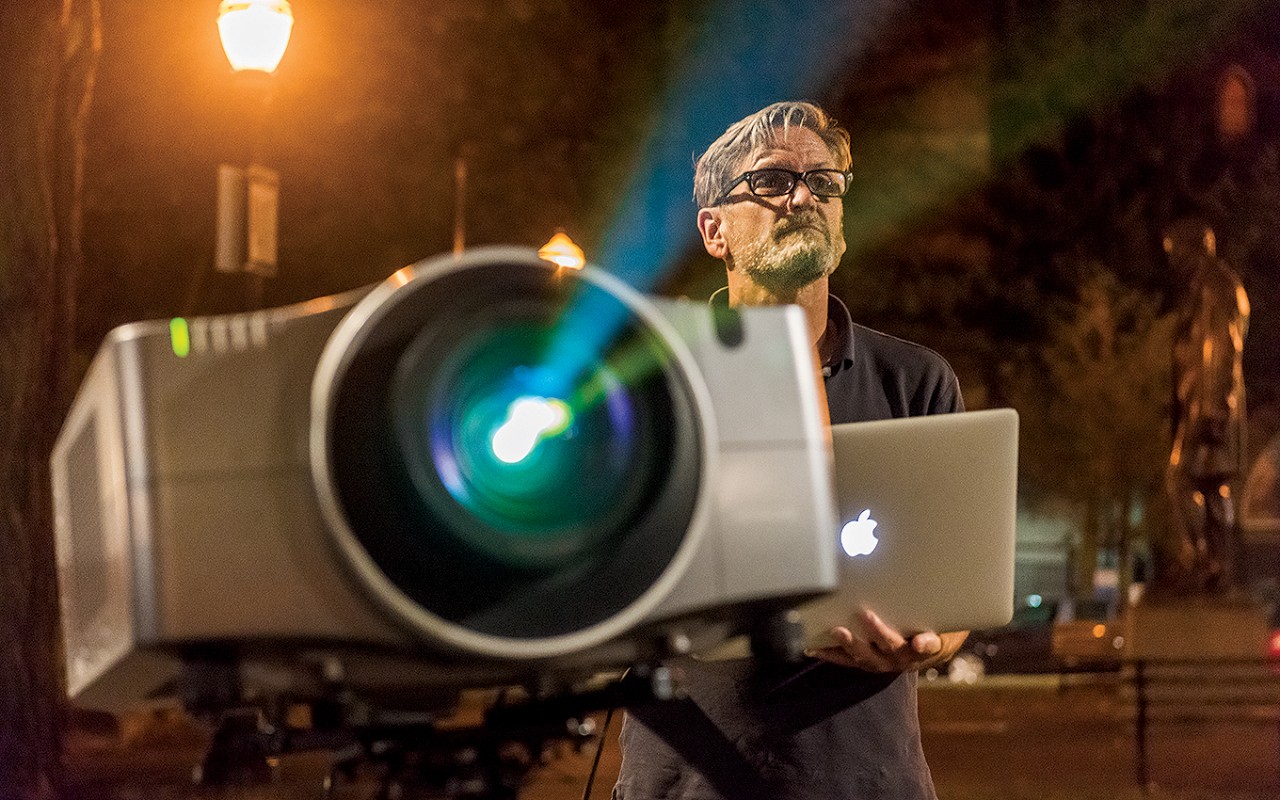 Facing across SW Park Avenue, Doyle operates a borrowed projector during the test of Presto! in Portland, Oregon, on August 8.