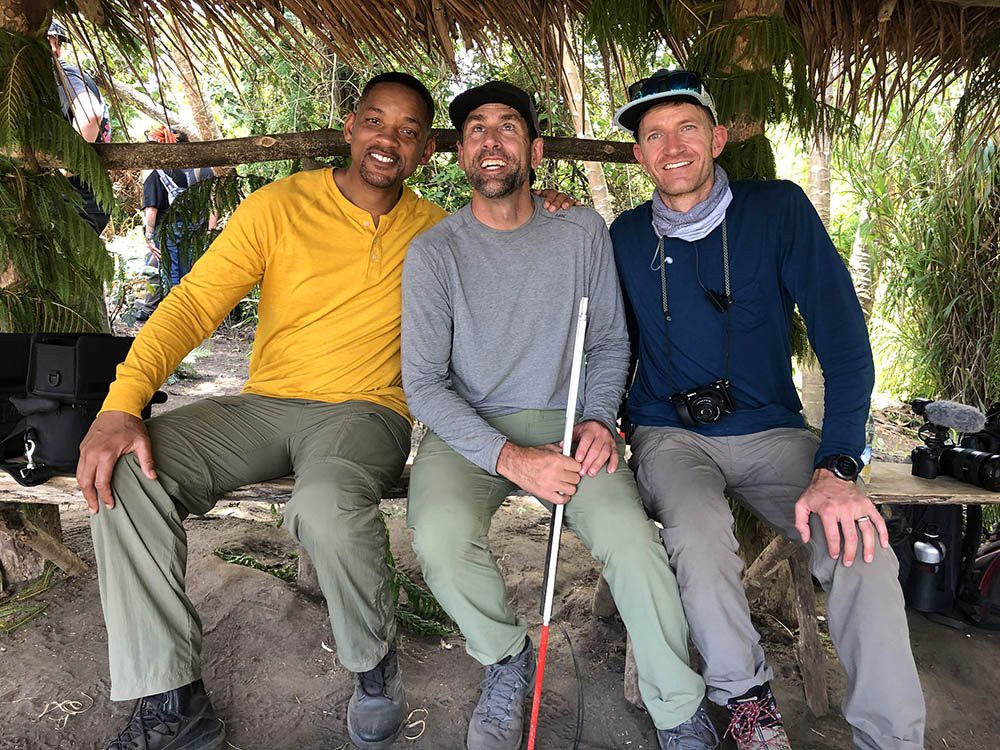 Will Smith, Erik Weihenmayer, and Skyler Williams sitting inside a traditional hut in the village of Yakel.