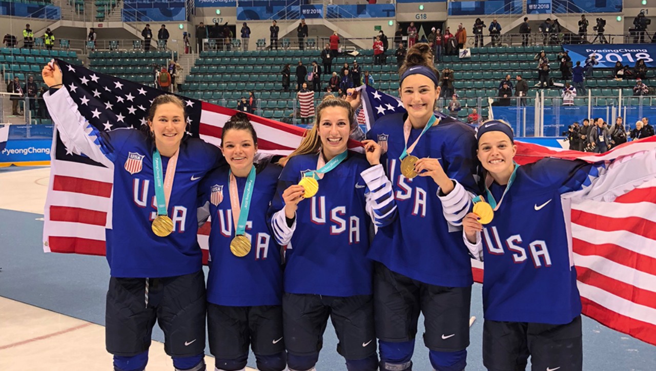 Team USA posing with gold medals and the flag