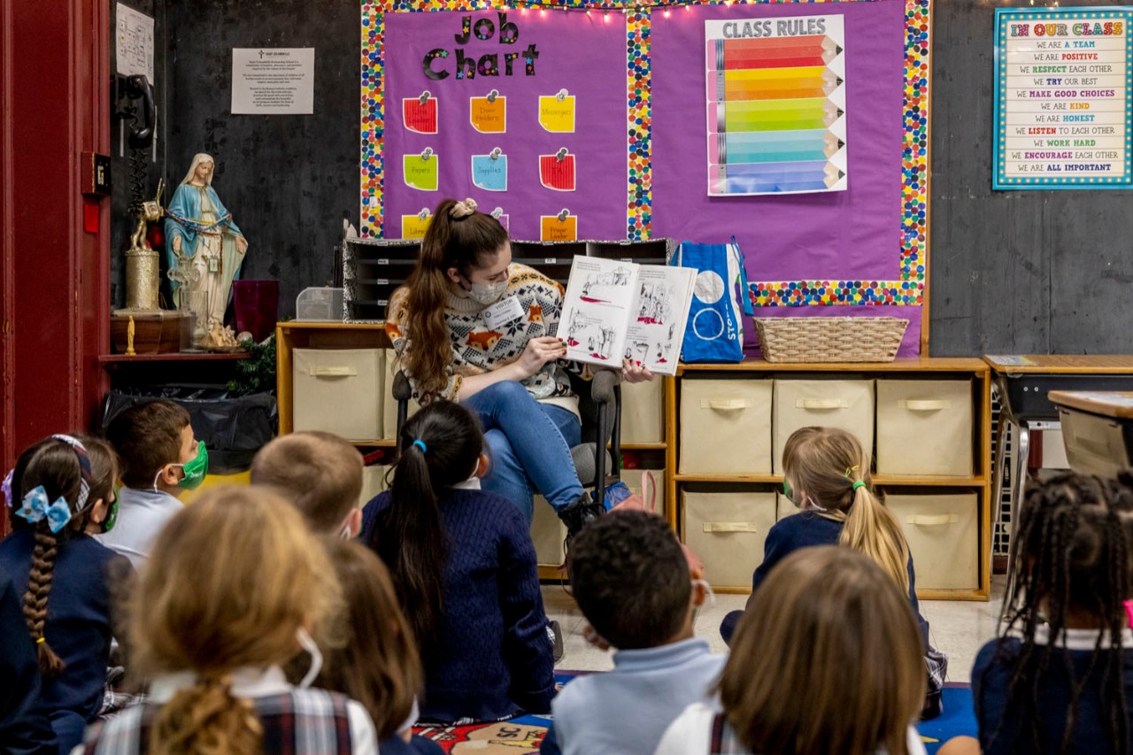 BC Read Aloud volunteer Hilary Crouteau, an acquisitons and fiscal assistant at O’Neill Library, introduces St. Columbkille students to 'Eloise at the Plaza.'