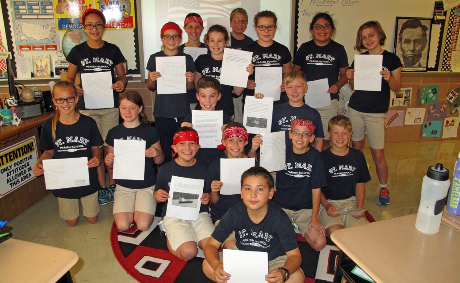 Fifth-graders at St. Mary's Parish School, some clad red bandannas in tribute to Welles Crowther's signature item of apparel, display their letters to his parents.