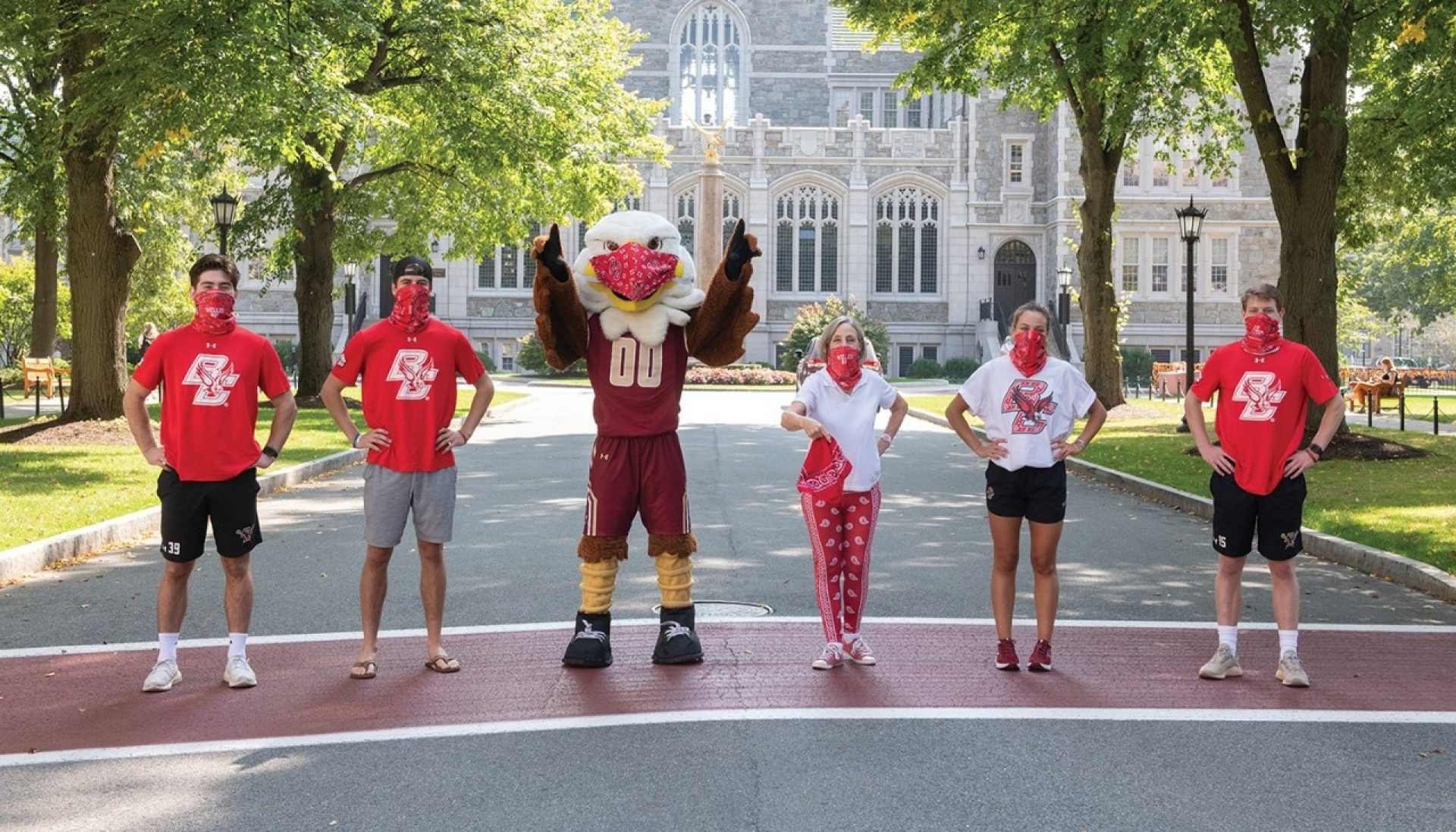 Students and the BC mascot wearing red bandanna masks