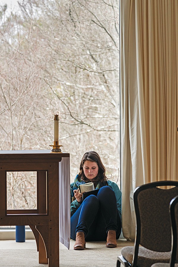 Ellen Hill writes in her journal in the Connors Center’s chapel