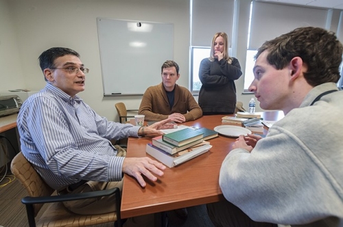 Director of Debate John Katsulas (left) talks with Fulton Debating Society members.