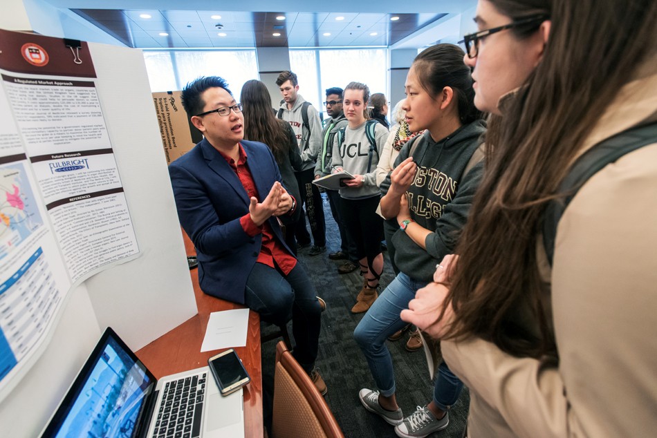 Undergraduate Poster Session for the Humanities in the Reading Room of O'Neill Library. Richard Balagtas A&S '16 explains his project to Allicen Dichiara A&S '16, graduate student Rachael Tully, Lauren Lin A&S '18, and Kejs Aliko A&S '18.