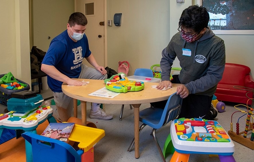 Two students cleaning a kids table