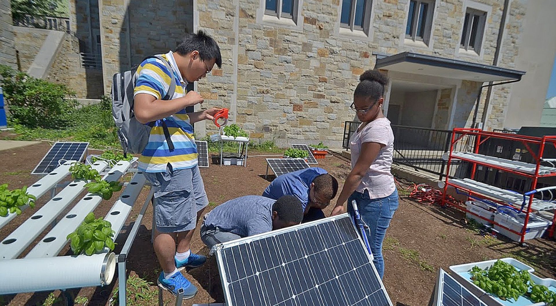 Lynn Sejour, a sophomore at the West Roxbury Education Complex, Yaderiz Mendez, and eighth grader at the James A. Hennigan K-8 School in Jamaica Plain, and Bryonia Brown, who will attend Brockton High School this fall, prepare a presentation for a project they completed during a two-week STEM workshop held on campus in July.