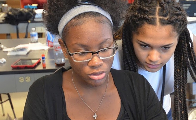 Lynn Sejour, a sophomore at the West Roxbury Education Complex, Yaderiz Mendez, an eighth grader at the James A. Hennigan K-8 School in Jamaica Plain, prepare a presentation for a project they completed during a two-week STEM workshop held on campus in July.