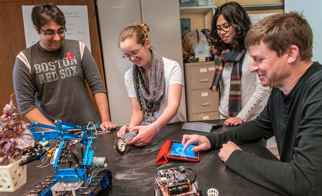 Michael Barnett working with students on a robotics project | Photo by Gary Gilbert