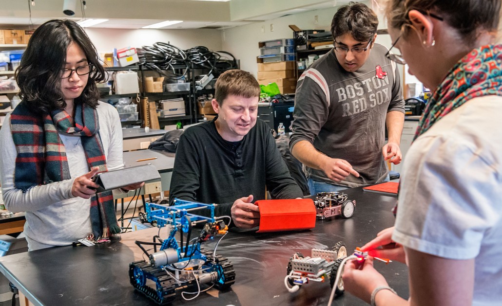 Michael Barnett working with students on a robotics project | Photo by Gary Gilbert