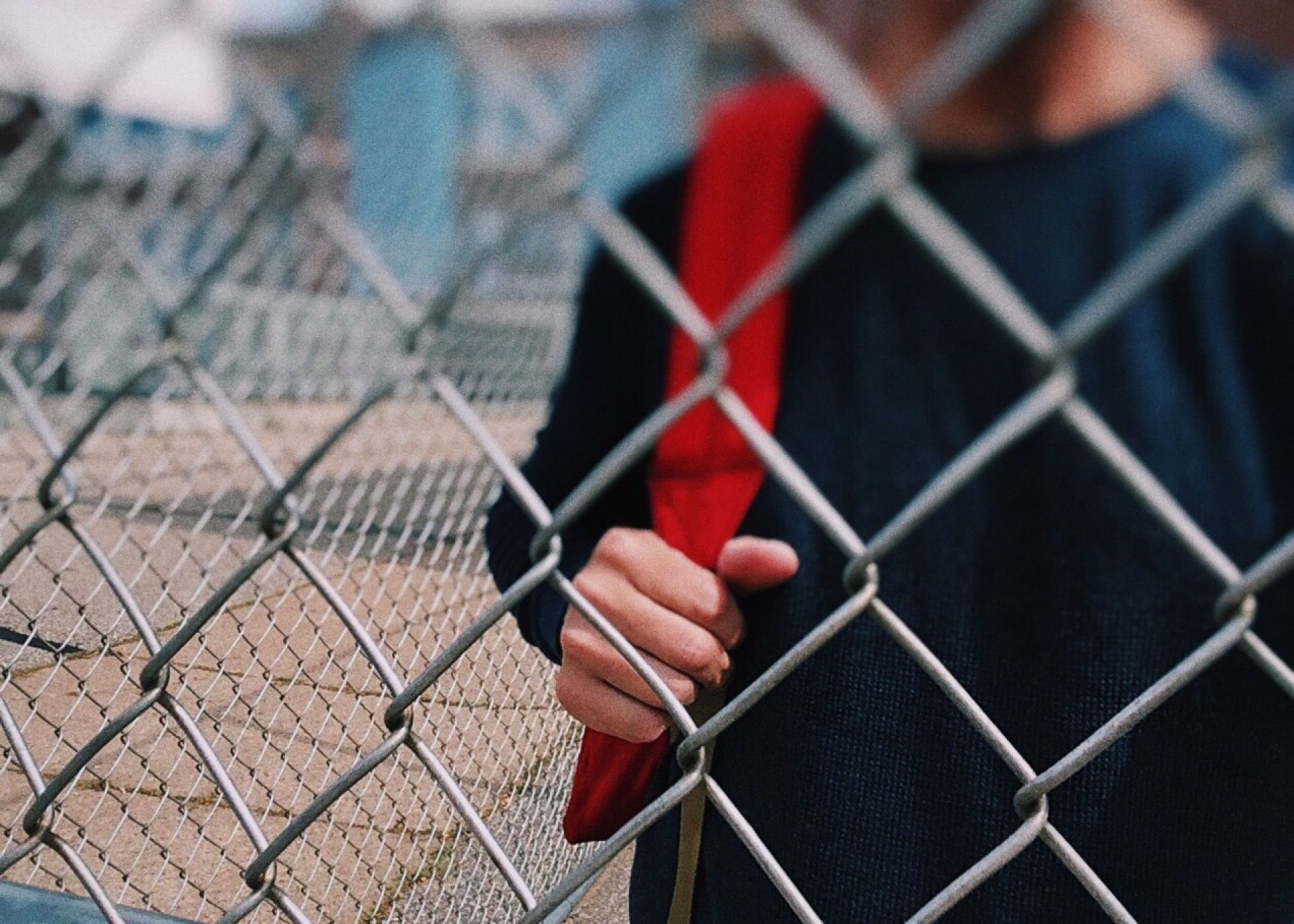 teen behind fence