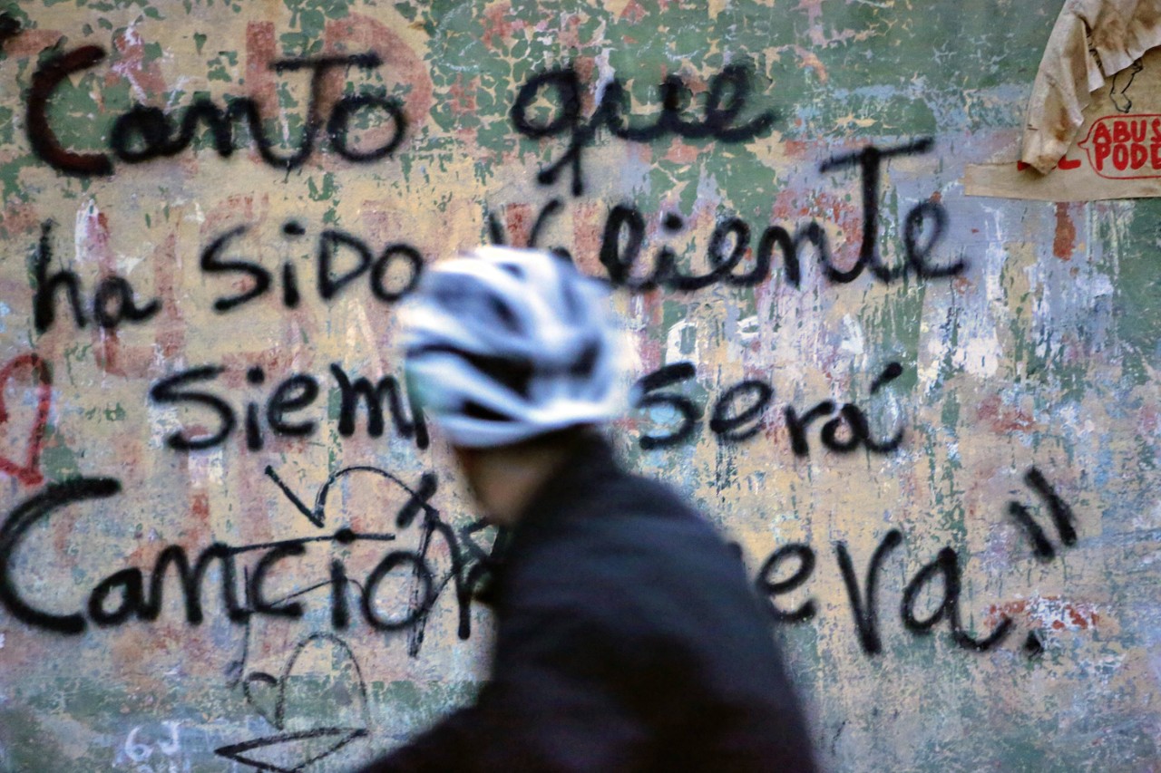 Assistant Professor of the Practice of Communication Marcus Breen rides a bicycle through Santiago's General Cemetery.