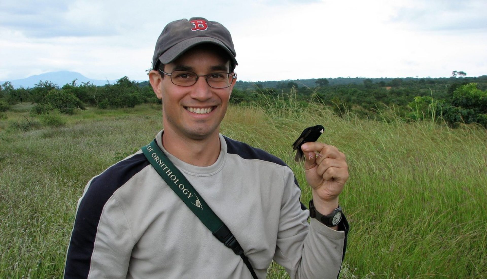 A man with a bird perched in his finger