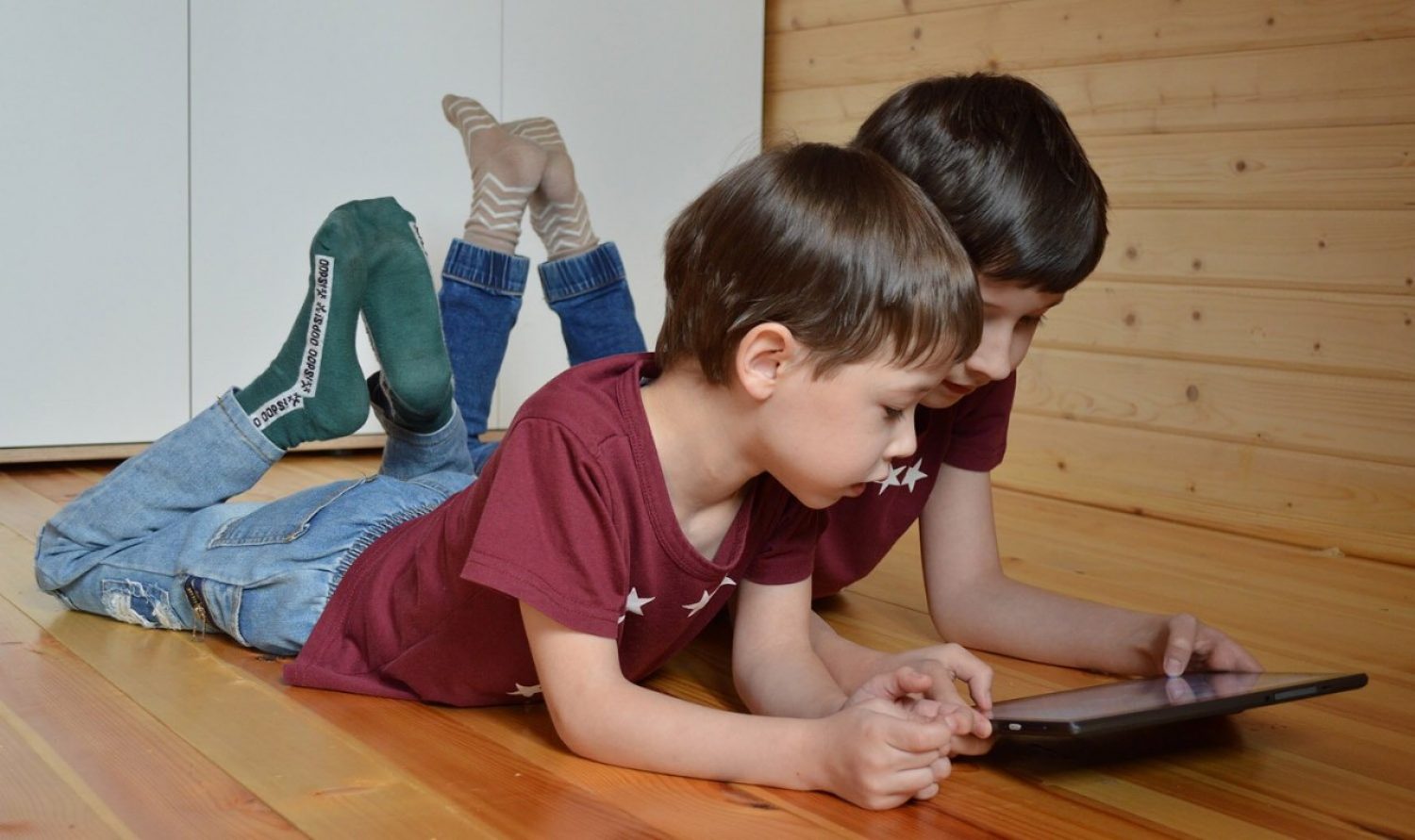 Two young kids looking at a tablet