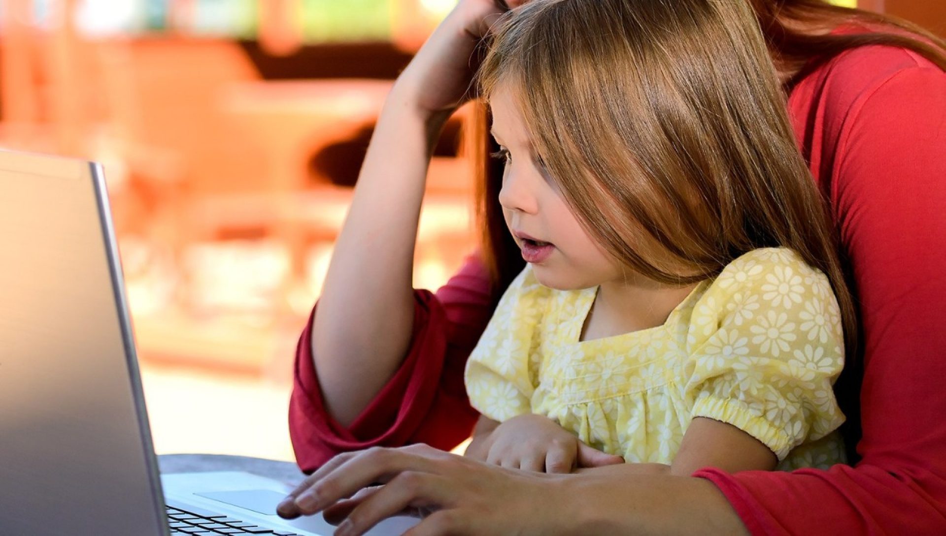 A child and adult using a laptop