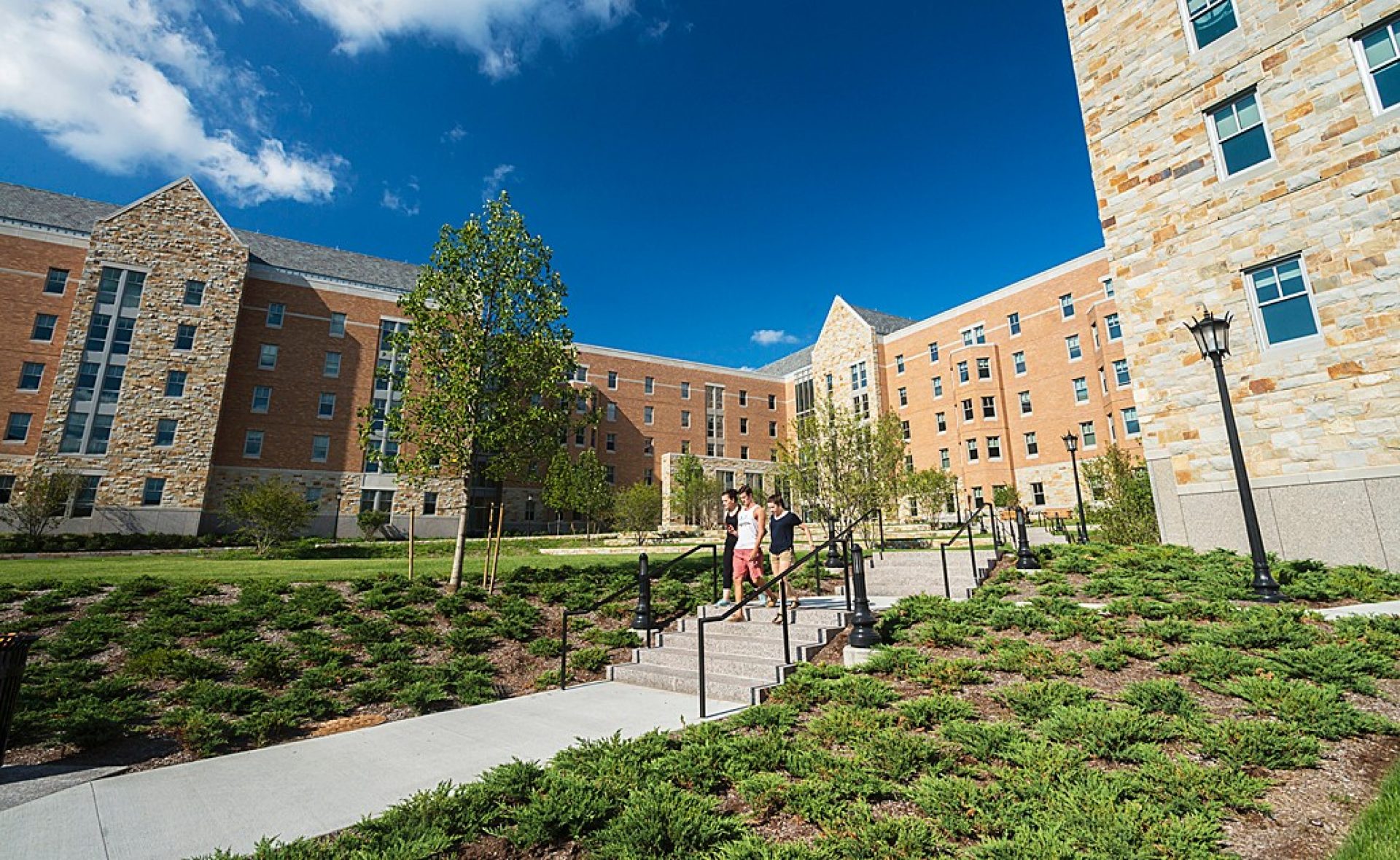 students walking out of the new St. Thomas More Apartments