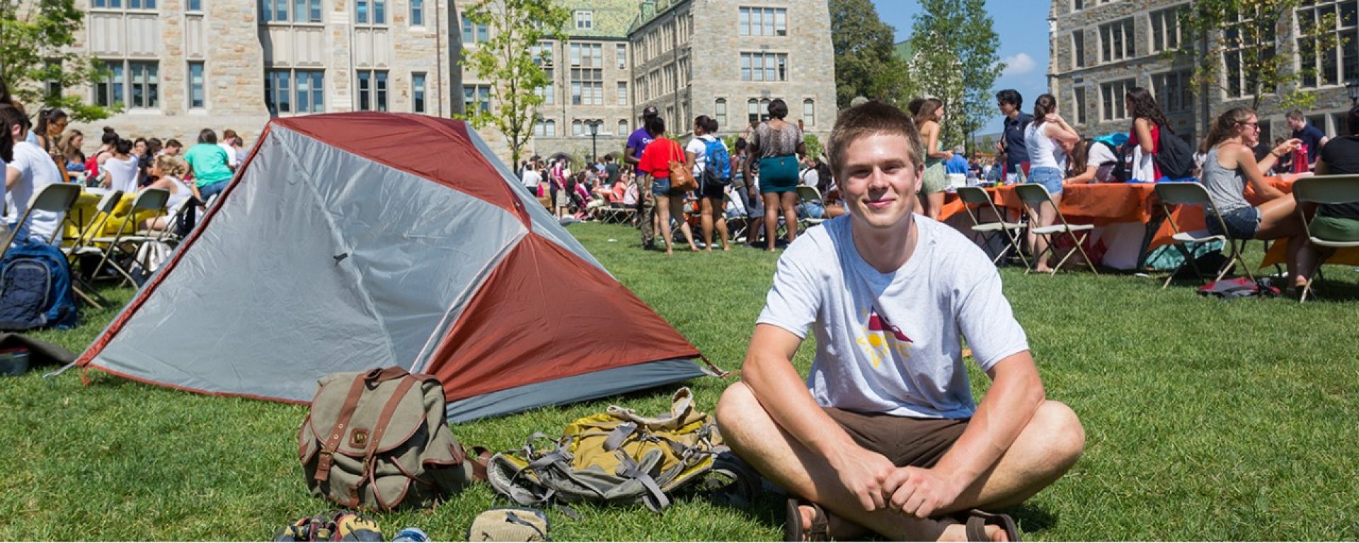 Boy sitting on grass during student fair