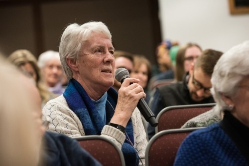 A member of the audience poses a question to the panelists.