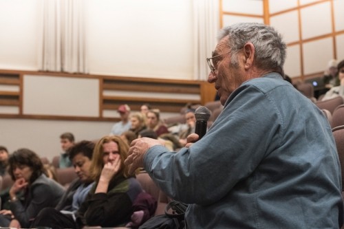 A member of the audience poses a question to the panelists.