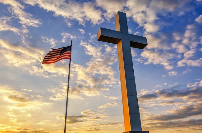 outside photo of a cross and the American flag