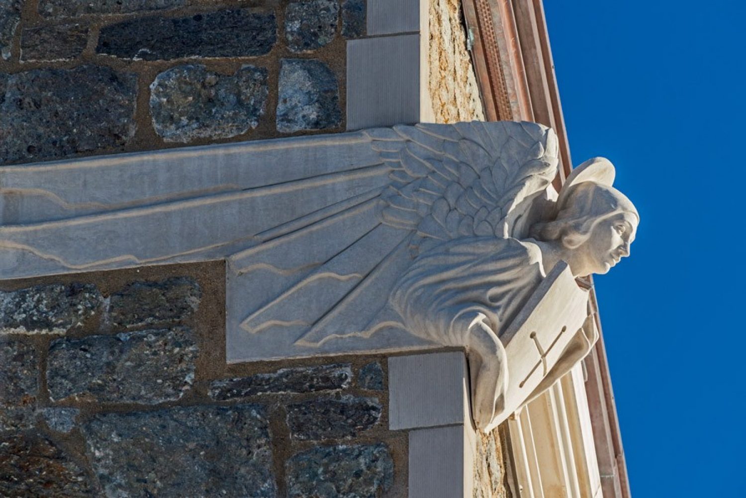 a statue of an angle placed on the corner of a building