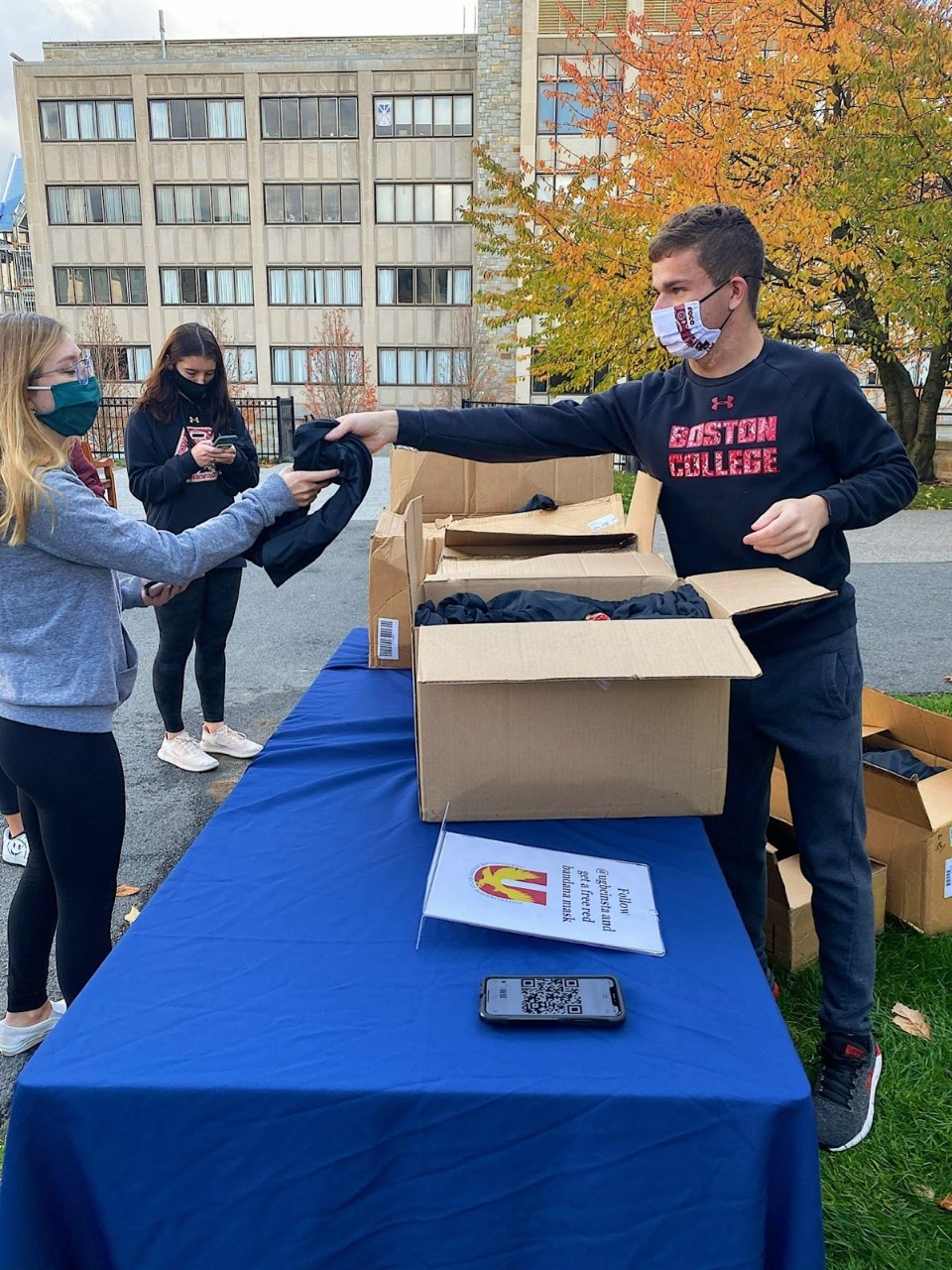 Christian Guma handing out shirts to BC students